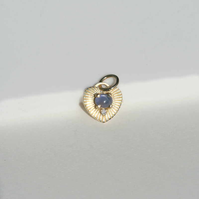 heart shaped star burst charm with blue star sapphire and diamond.